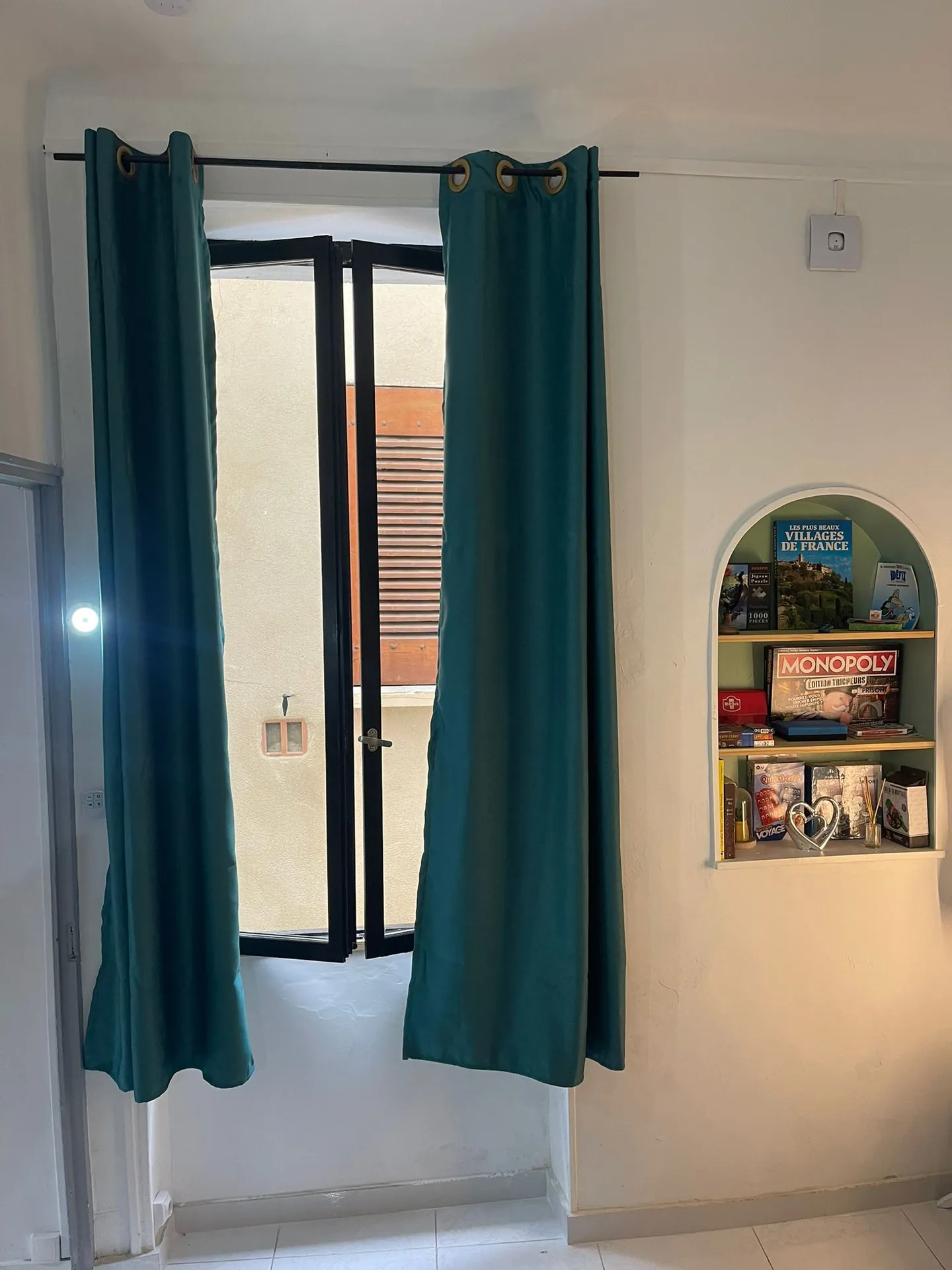 Fenêtre aux rideaux turquoise et coin jeux